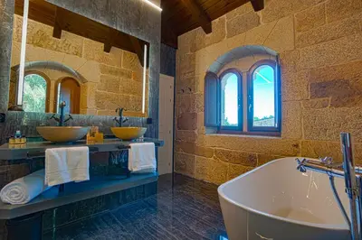 a bathroom with two sinks and a bath tub at Hotel As Torres da Hermida in Monterroso