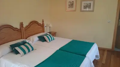 a bedroom with two beds with green and white pillows at Casa O Torgal in Parada del Sil