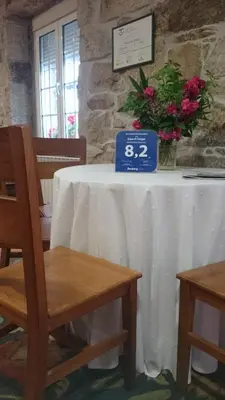 a table with a white table cloth and flowers on it at Casa O Torgal in Parada del Sil