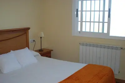 a bedroom with a bed with white sheets and a window at Casa O Torgal in Parada del Sil