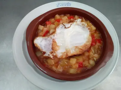 a bowl of food with a fried egg on top at Arume in Bóveda