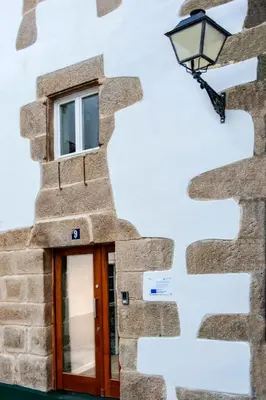 a building with a street light on the side of it at SNÖ Camino do Eume Apartamentos in Puentedeume