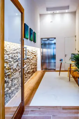 an office with a stone wall and a glass door at SNÖ Camino do Eume Apartamentos in Puentedeume