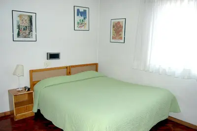 a bedroom with a green bed and a window at Hostal Charo II in Santiago de Compostela