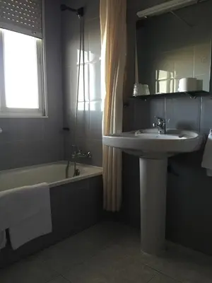 a bathroom with a sink and a bath tub at Hotel Restaurante Derby in Carballino