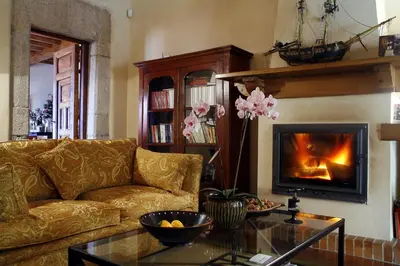 a living room with a couch and a fireplace at Hotel Rural Palacio de Prelo in Boal