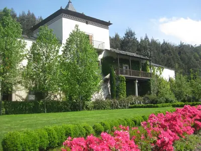 a house with a garden with pink flowers at Hotel Rural Palacio de Prelo in Boal