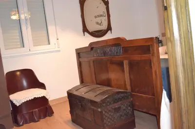 a room with a chair and a clock on the wall at O Prado do Forno in O Barco de Valdeorras