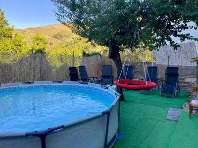 a large swimming pool with chairs and a tree at O Prado do Forno in O Barco de Valdeorras