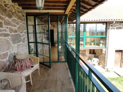 a balcony of a house with a stone wall at Casa Rural Rectoral de Candás in Rairiz de Veiga