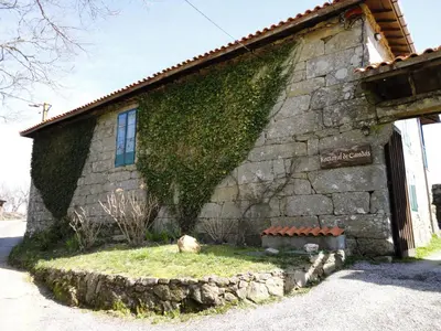 a building with ivy growing on the side of it at Casa Rural Rectoral de Candás in Rairiz de Veiga