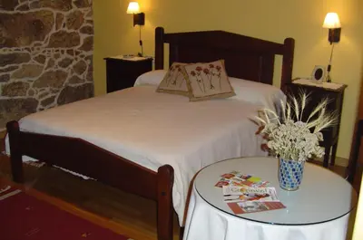 a bedroom with a bed and a table with a table sidx sidx sidx at Casa Rural Rectoral de Candás in Rairiz de Veiga