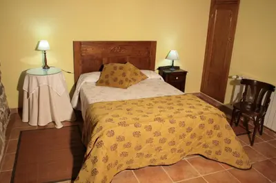 a bedroom with a bed with a yellow blanket on it at Casa Rural Rectoral de Candás in Rairiz de Veiga