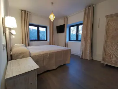 a bedroom with a bed and two windows at VILLA MAREL in Trefacio