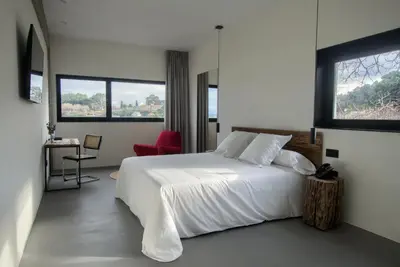 a bedroom with a white bed and a red chair at AFTER Hotel in Bastiagueiro