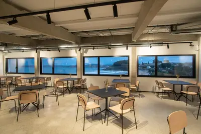 a room with tables and chairs and windows at AFTER Hotel in Bastiagueiro