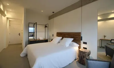 a bedroom with a white bed and a mirror at AFTER Hotel in Bastiagueiro