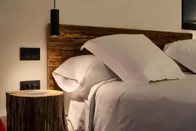 a bed with white pillows and a wooden headboard at AFTER Hotel in Bastiagueiro