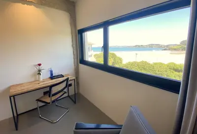 a room with a desk and a large window at AFTER Hotel in Bastiagueiro