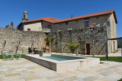 a stone building with a pool in front of a house at CASA RECTORAL DE SAN EUSEBIO in Ourense