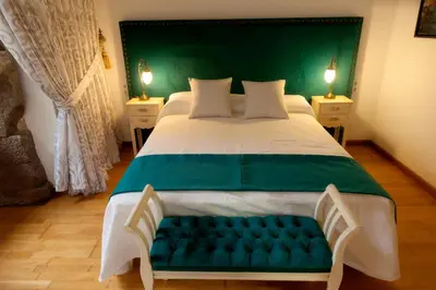 a bedroom with a large bed with a green headboard at CASA RECTORAL DE SAN EUSEBIO in Ourense