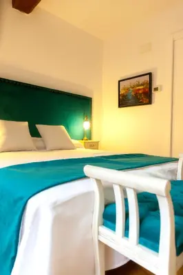 a bedroom with a large bed with a green headboard at CASA RECTORAL DE SAN EUSEBIO in Ourense