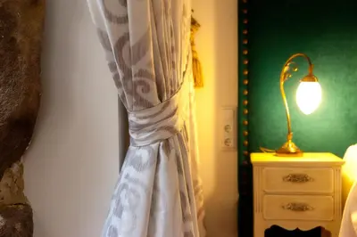 a curtain hanging in a bedroom next to a lamp at CASA RECTORAL DE SAN EUSEBIO in Ourense