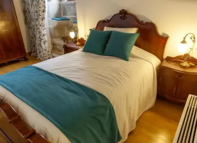a bedroom with a large bed with blue pillows at CASA RECTORAL DE SAN EUSEBIO in Ourense