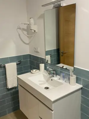 a bathroom with a sink and a mirror at Os Arcos - Apartamentos Turísticos in Portomarin