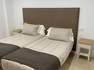 two beds sitting next to each other in a room at Os Arcos - Apartamentos Turísticos in Portomarin