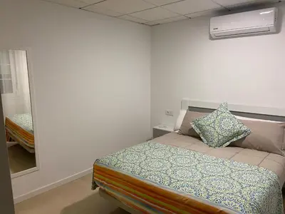 a small bedroom with a bed and a mirror at Os Arcos - Apartamentos Turísticos in Portomarin