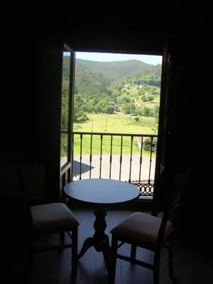 a table and two chairs in a room with a window at Apartamentos Rurales Posada de las Hoces in Bustiello de Paredes
