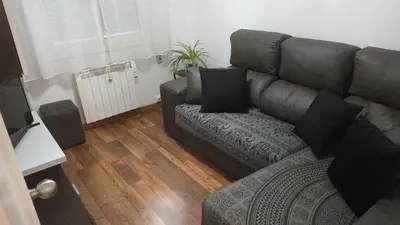 a living room with a brown couch and a television at Enseñanza in Ourense