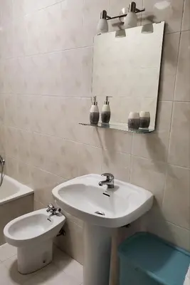 a bathroom with a sink and a mirror and a toilet at Piso termal in Ourense