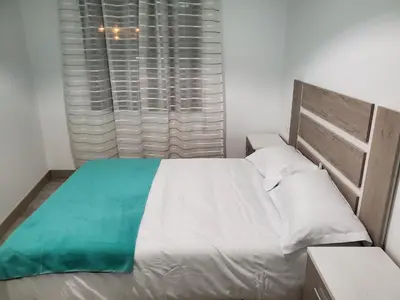 a bedroom with a large white bed and a window at Piso termal in Ourense