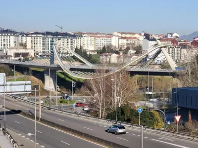 a bridge over a highway in a city with buildings at Piso termal in Ourense