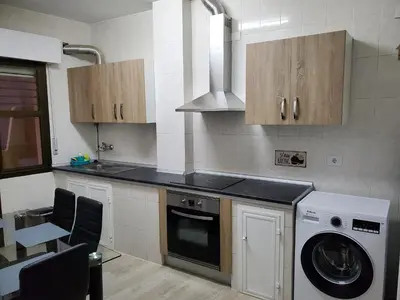 a kitchen with a washing machine and a washer at Piso termal in Ourense