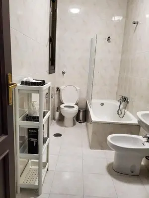 a bathroom with a toilet and a tub and a sink at Piso termal in Ourense