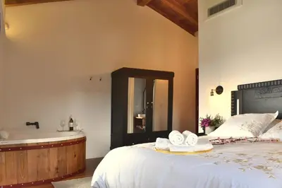 a bedroom with a tub and a bed with towels at Gandarela Turismo Rural in Ourense