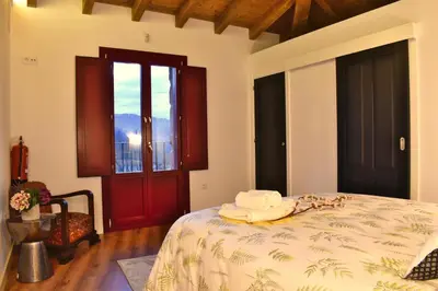 a bedroom with a bed and a red door at Gandarela Turismo Rural in Ourense