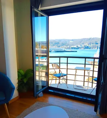 a room with a balcony with a view of the water at Portbeach in Viveiro