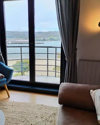 a room with a large window with a view of the water at Portbeach in Viveiro