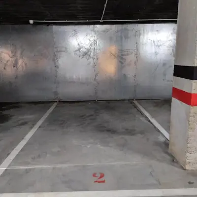 an empty parking garage with a sign on the floor at Portbeach in Viveiro
