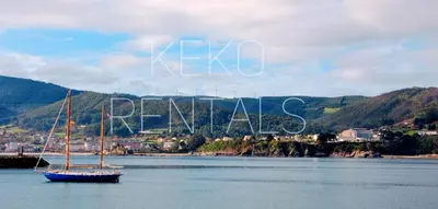 a boat in a body of water with a town in the background at Portbeach in Viveiro