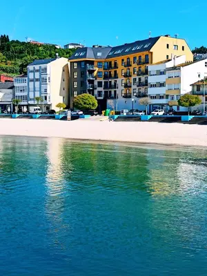 a view of a beach with buildings and the water at Portbeach in Viveiro