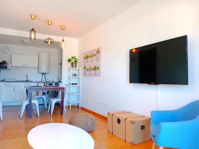 a living room with a tv and a table with chairs at Portbeach in Viveiro