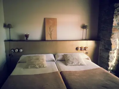 a bed with two pillows on it in a room at Hostal De Montaña La Aldeya in Villablino