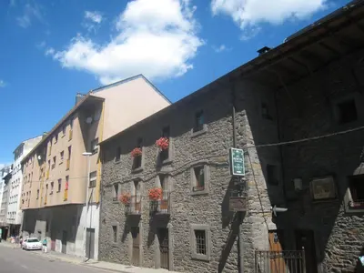 a stone building with flower boxes on the side of it at Hostal De Montaña La Aldeya in Villablino