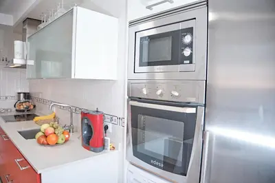 a kitchen with a stainless steel refrigerator and a sink at Peregrina Pensión 2 in O Pedrouzo