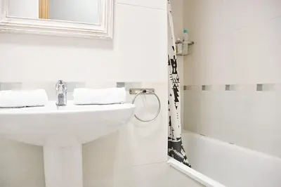 a white bathroom with a sink and a bath tub at Peregrina Pensión 2 in O Pedrouzo